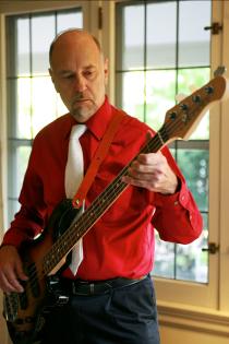 Close-up of Cy Edmunds playing electric bass at a gig
